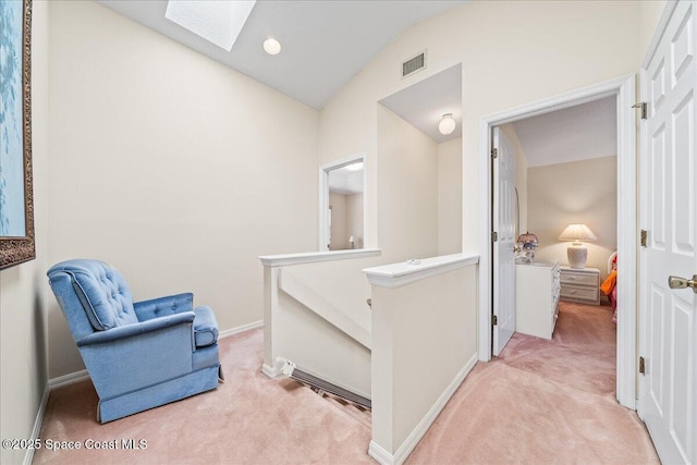 sitting room featuring light colored carpet and lofted ceiling with skylight