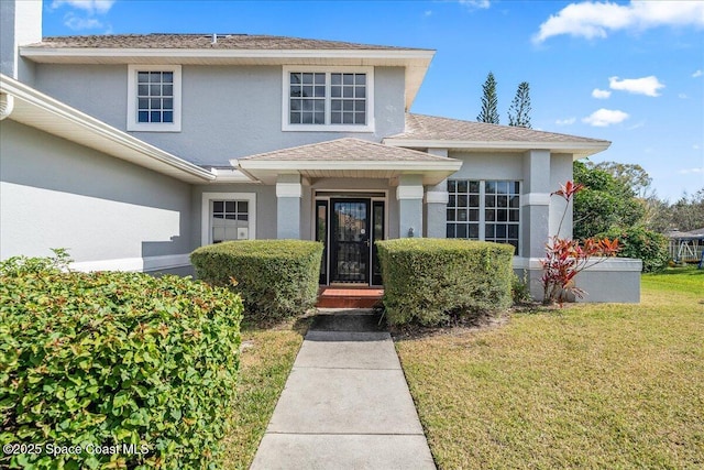 entrance to property featuring a lawn