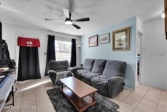 living room featuring ceiling fan, light tile patterned flooring, and a textured ceiling