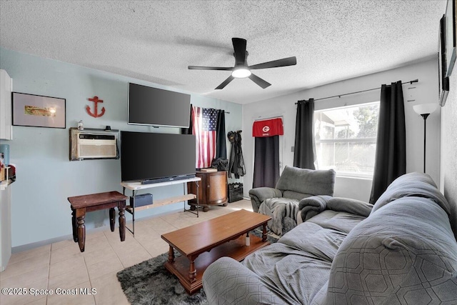 living room featuring ceiling fan, light tile patterned flooring, an AC wall unit, and a textured ceiling