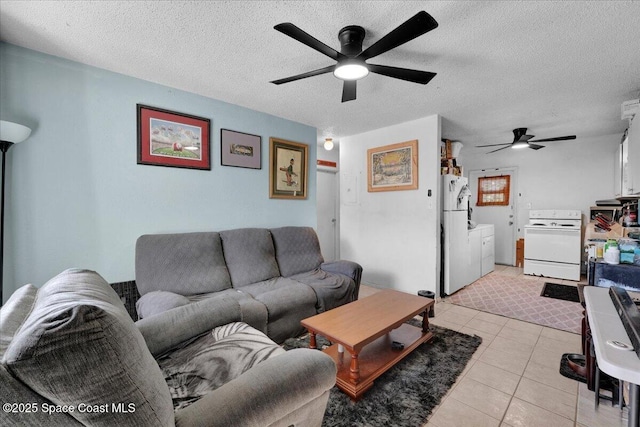 tiled living room with washer and dryer, ceiling fan, and a textured ceiling