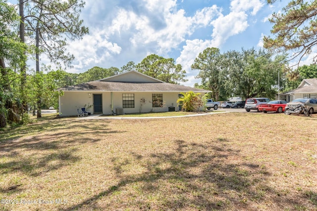 exterior space with central air condition unit and a front lawn