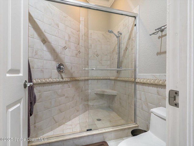 bathroom featuring toilet and a shower with door