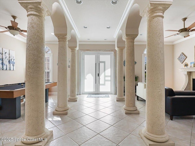 entryway with a high end fireplace, a wealth of natural light, and ornamental molding