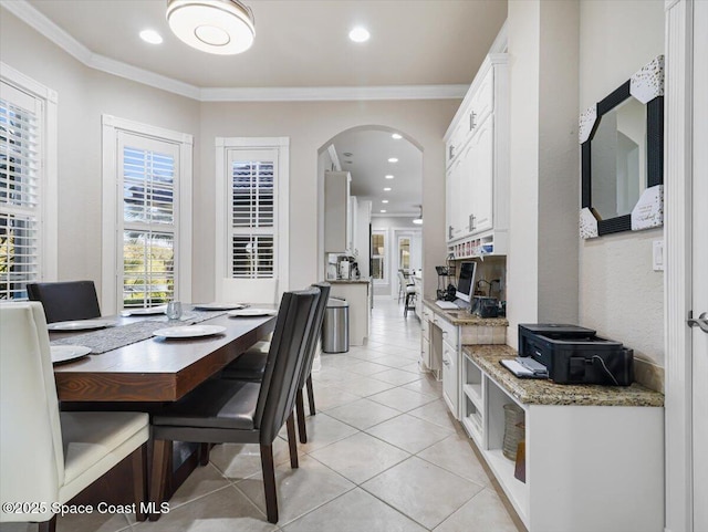 dining area with ornamental molding and light tile patterned flooring