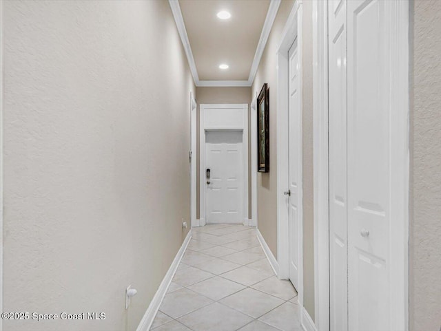 corridor featuring light tile patterned floors and ornamental molding