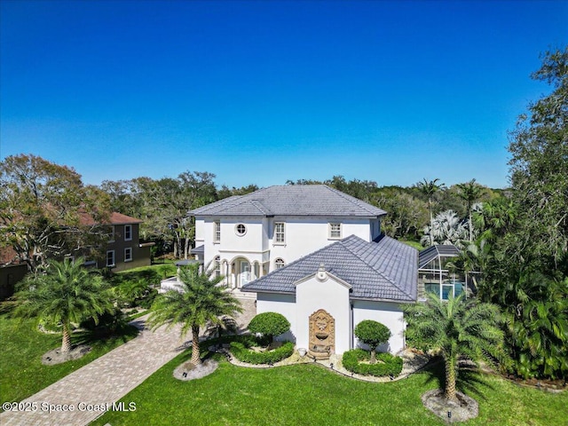 mediterranean / spanish house featuring a lanai and a front yard