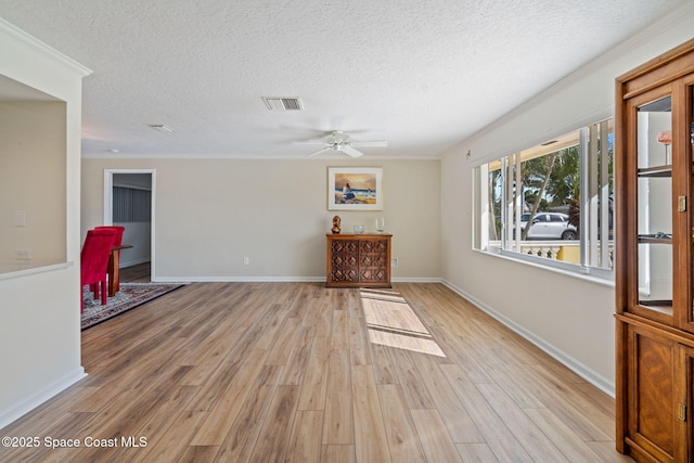 spare room with a textured ceiling, light wood-type flooring, and visible vents