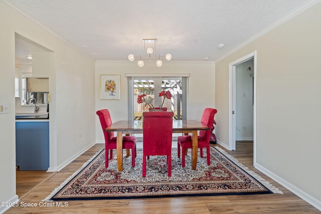 dining room featuring an inviting chandelier, ornamental molding, and hardwood / wood-style floors