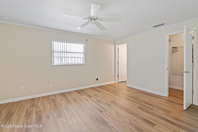 interior space featuring a closet, light hardwood / wood-style floors, crown molding, ceiling fan, and a spacious closet