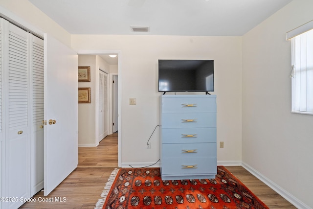 unfurnished bedroom featuring baseboards, visible vents, and light wood-style floors