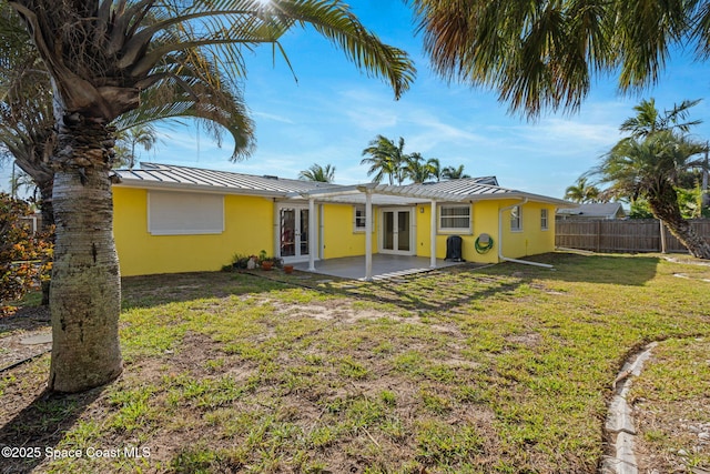 rear view of house featuring french doors, a yard, and a patio area