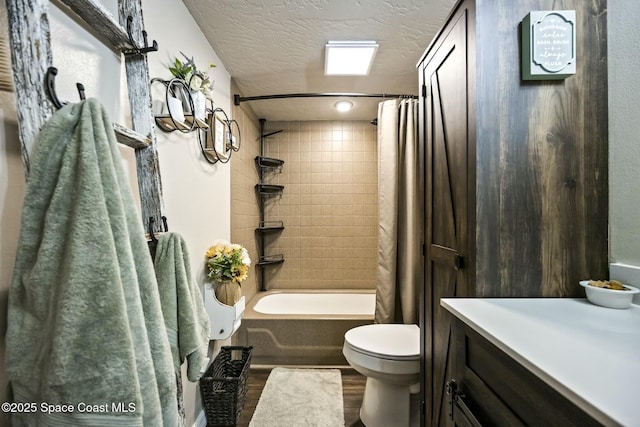 full bathroom featuring vanity, a textured ceiling, shower / bathtub combination with curtain, hardwood / wood-style floors, and toilet