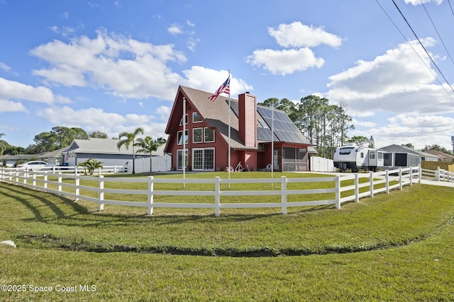 view of front of property with a front yard, solar panels, and a rural view