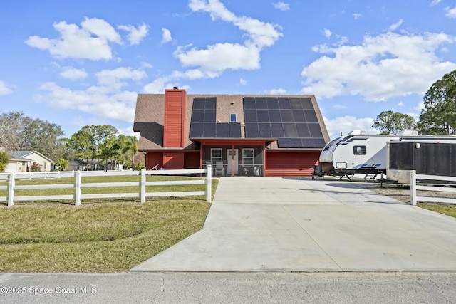 view of front of house featuring a front yard and solar panels