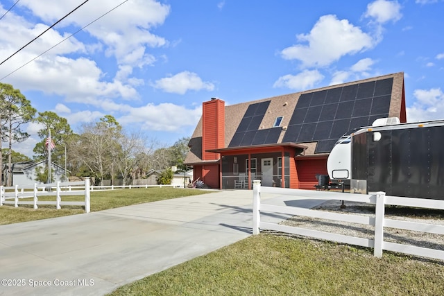 view of front of home with solar panels and a front lawn