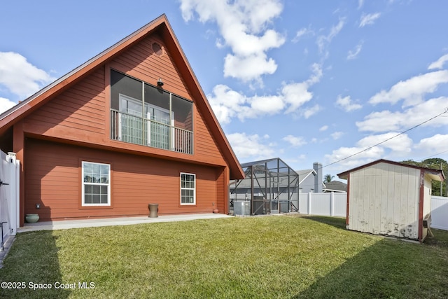 back of property with a lanai, a yard, a storage unit, and cooling unit