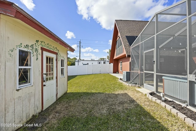 view of yard with a lanai and central air condition unit