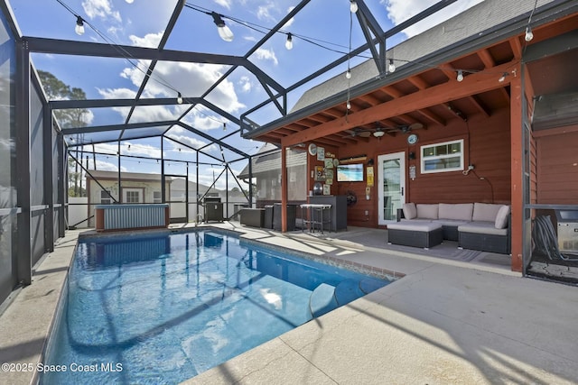 view of swimming pool featuring an outdoor living space, glass enclosure, exterior bar, ceiling fan, and a patio