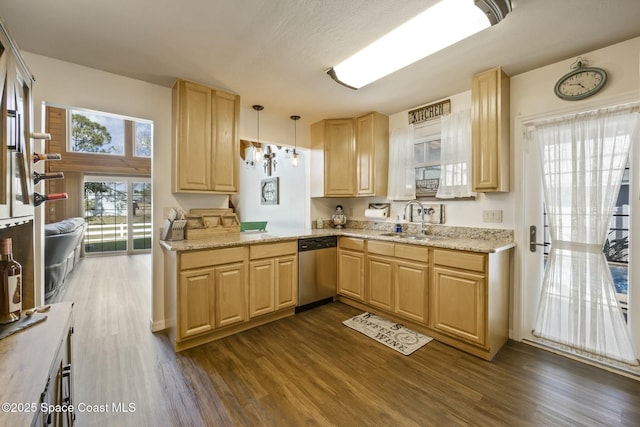 kitchen featuring dishwasher, pendant lighting, light brown cabinets, and sink