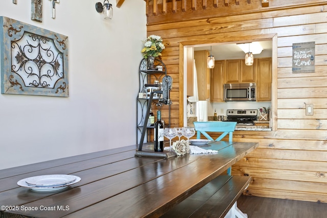 dining room featuring dark hardwood / wood-style floors, wood walls, and rustic walls