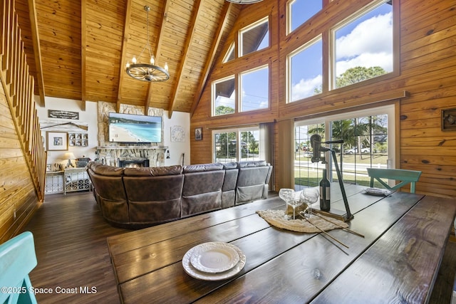 dining space featuring wood ceiling, beam ceiling, hardwood / wood-style flooring, high vaulted ceiling, and a fireplace