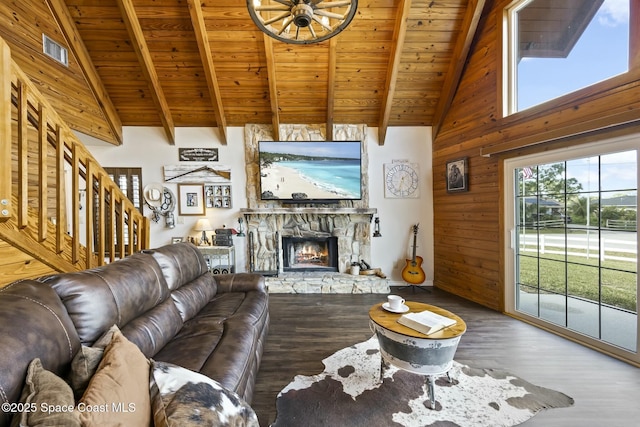 living room with beamed ceiling, wood ceiling, a fireplace, and wood walls