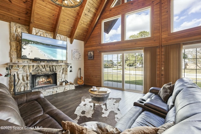 living room featuring hardwood / wood-style floors, wooden ceiling, wooden walls, a fireplace, and beamed ceiling