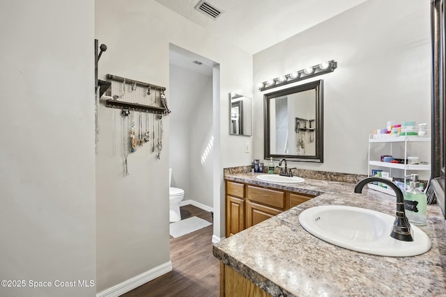 bathroom with hardwood / wood-style flooring, vanity, and toilet