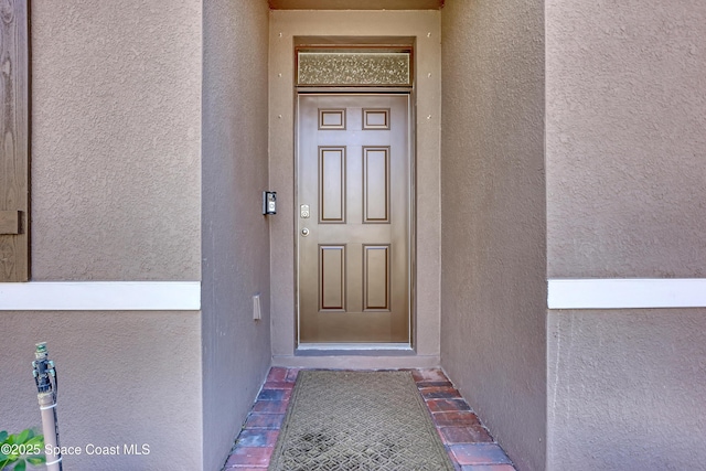 entrance to property featuring stucco siding