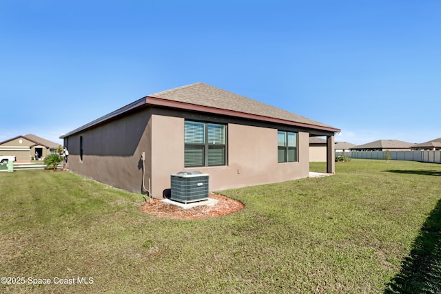 view of side of home featuring central AC unit and a lawn