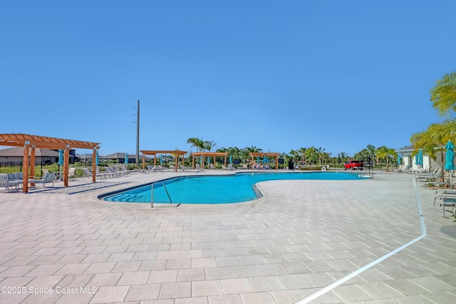 view of swimming pool with a patio and a pergola