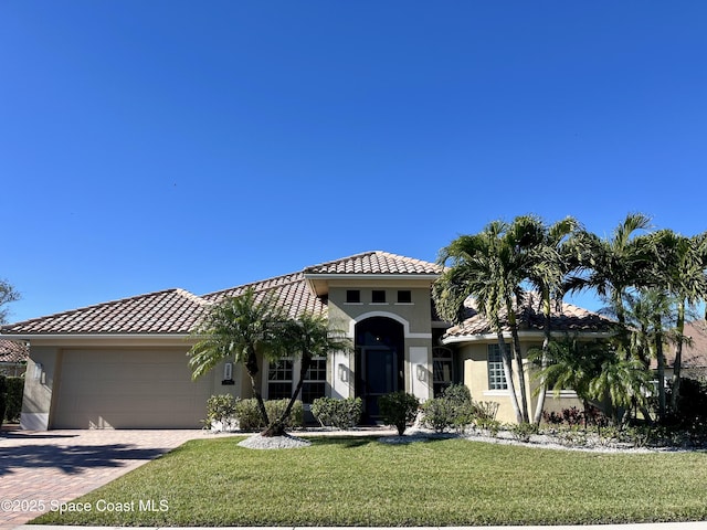 mediterranean / spanish-style home with a front yard and a garage