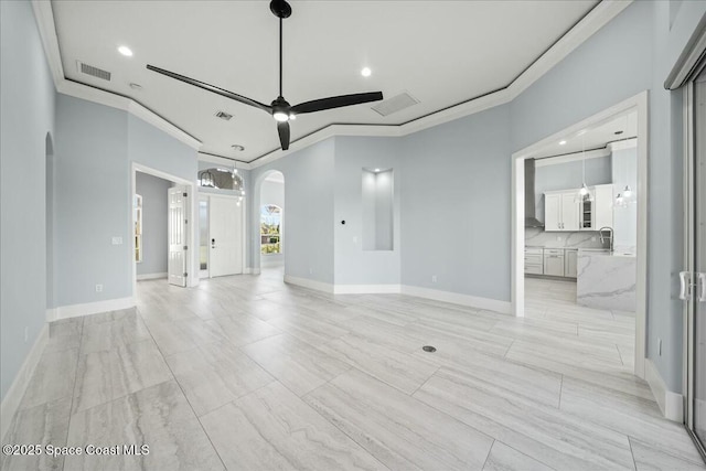 unfurnished living room featuring crown molding, ceiling fan, and sink