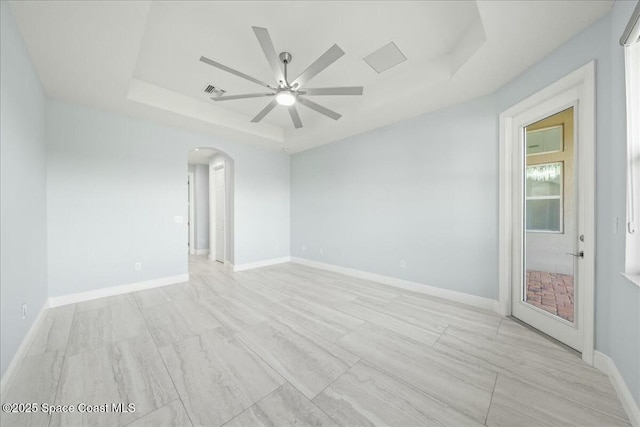 spare room with a raised ceiling and ceiling fan