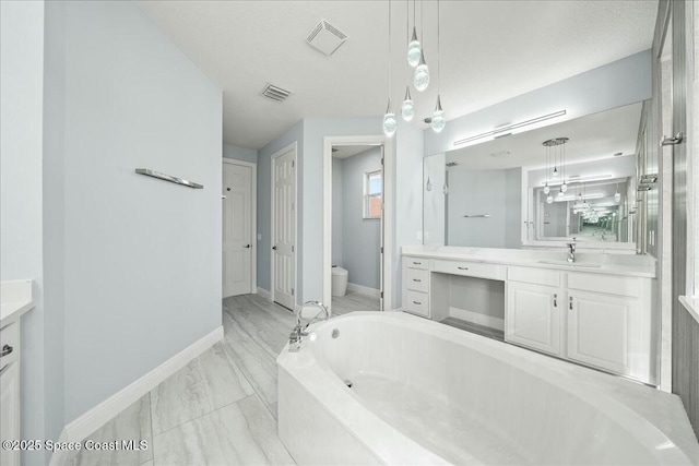 bathroom featuring vanity, a washtub, and toilet