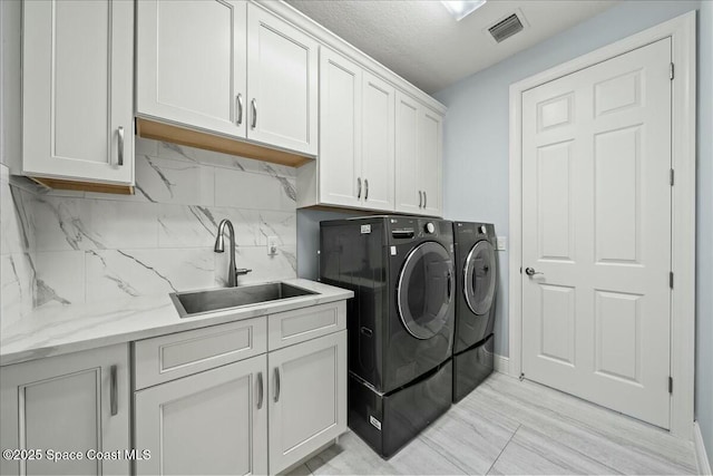 laundry area featuring sink, cabinets, and independent washer and dryer