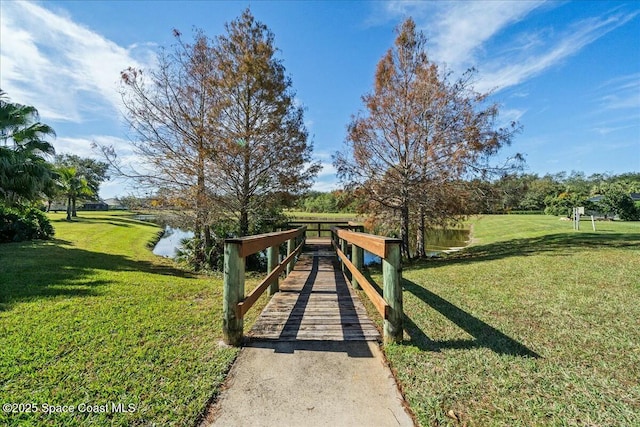 view of community with a yard and a water view