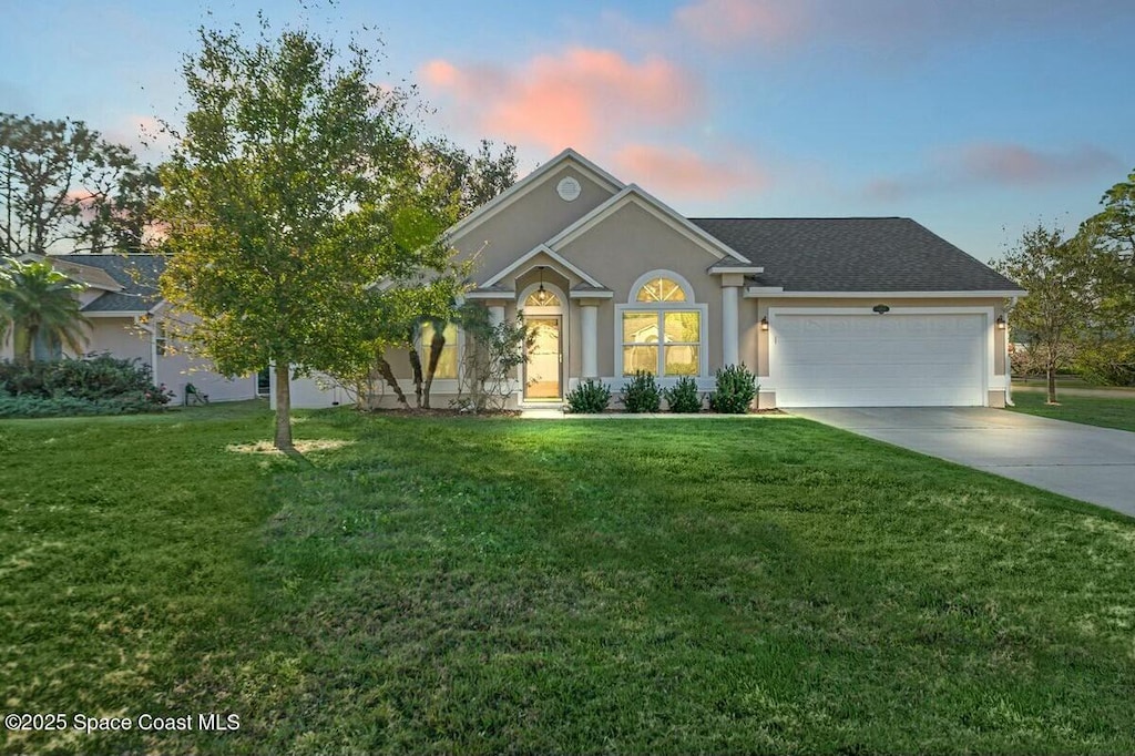 ranch-style home with a yard and a garage