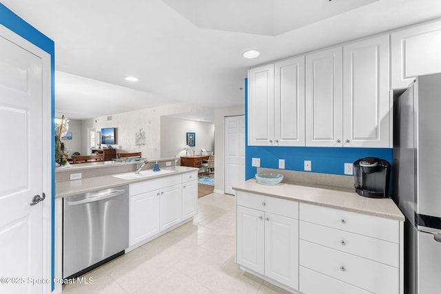 kitchen with stainless steel appliances, white cabinets, and sink