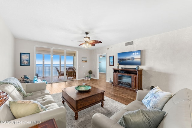 living room featuring light wood-type flooring and ceiling fan