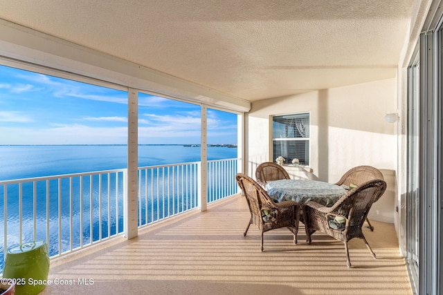 sunroom / solarium featuring a water view