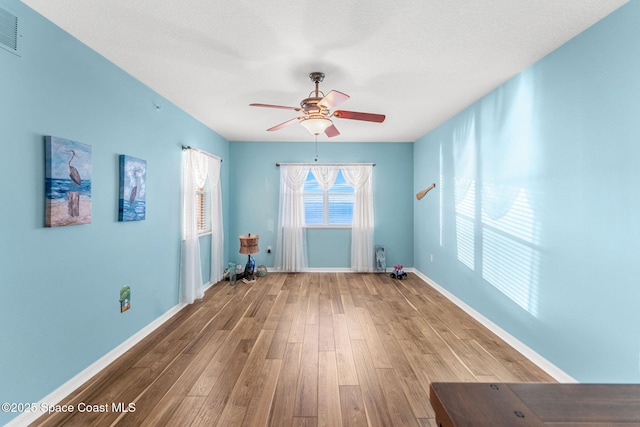 unfurnished room with a textured ceiling, ceiling fan, and hardwood / wood-style floors