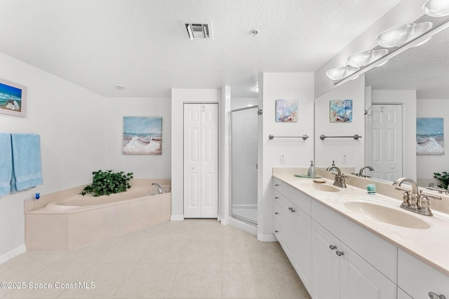 bathroom featuring a textured ceiling, tile patterned floors, vanity, and shower with separate bathtub