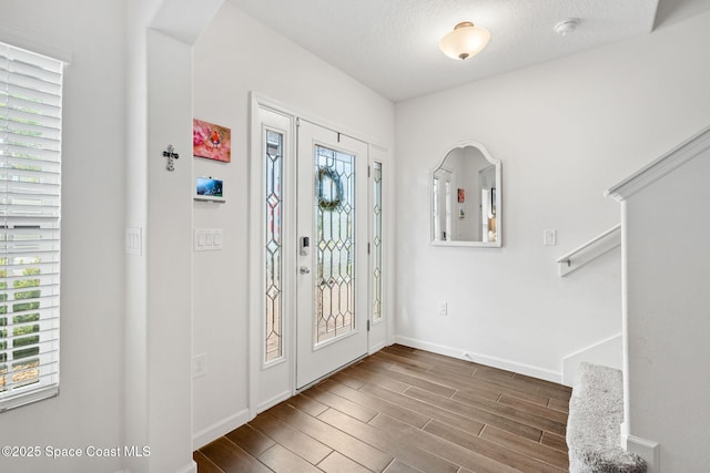 entrance foyer with a textured ceiling and dark wood-type flooring