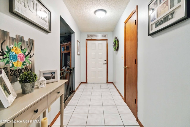 doorway with a textured ceiling and light tile patterned floors