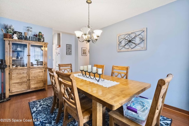 dining room featuring a notable chandelier and dark hardwood / wood-style floors