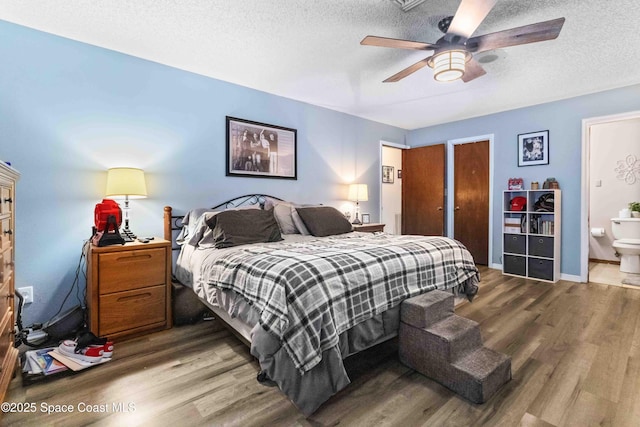 bedroom featuring a textured ceiling, ceiling fan, ensuite bathroom, and wood-type flooring