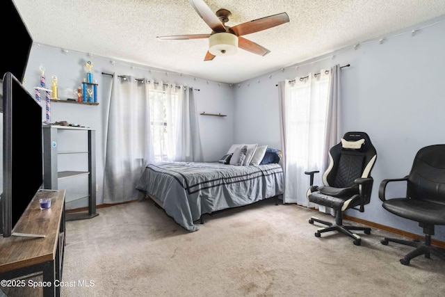 bedroom featuring ceiling fan, a textured ceiling, and carpet flooring