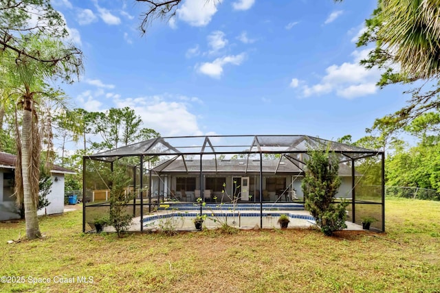 back of house featuring a yard and glass enclosure